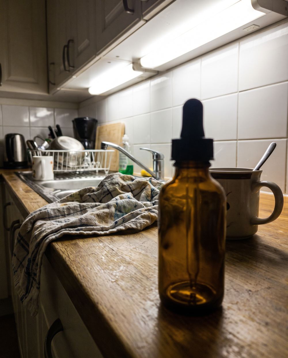 A serum bottle photographed on a messy kitchen bench